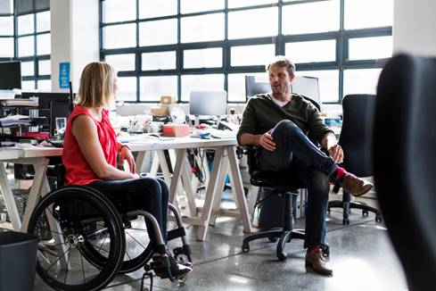 Woman in wheel chair talking to coworker - Wrongful Termination